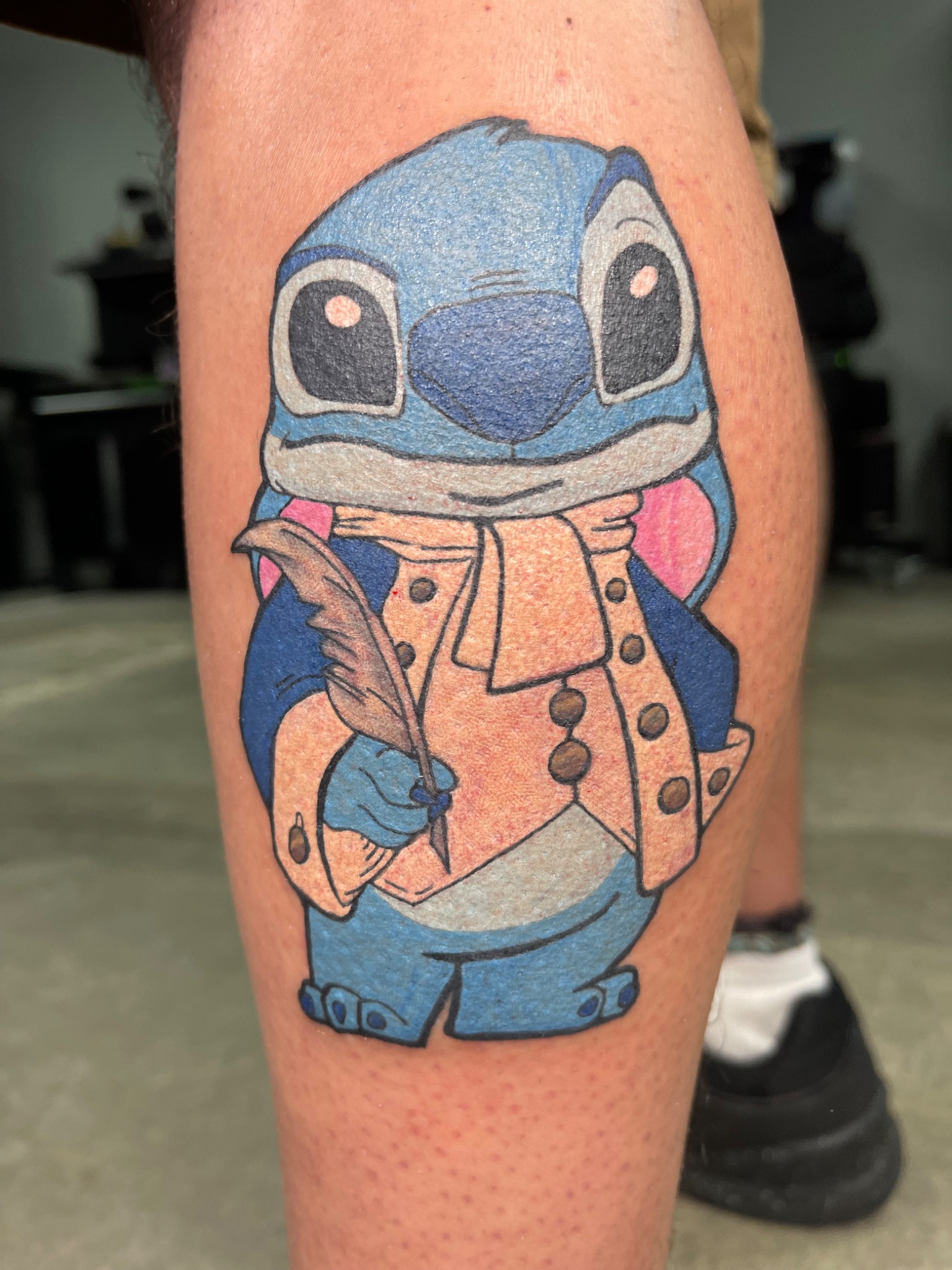 Close detail of colorful Stitch tattoo