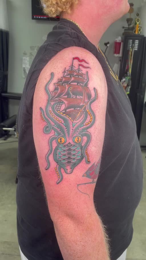 Illustrative grenade and snake upper-arm tattoo